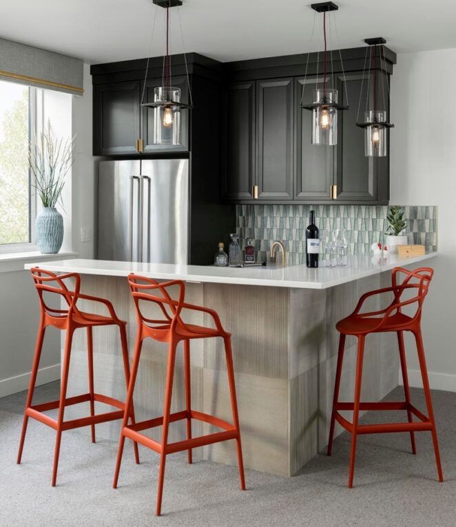 Image of kitchen bar with bright red bar stool, dark cabinetry, and creative tile backsplash; design by rebaL design, photography by Kimberly Gavin